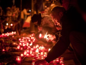 People light candles in memory of the victims of clashes between police and protesters in Ukraine, in Bucharest, Romania, Friday, Feb. 21, 2014. In a day that could significantly shift Ukraine’s political destiny, opposition leaders signed a deal Friday with the country’s beleaguered president that calls for early elections, a new constitution and a new unity government. (Andreea Balaurea/The Associated Press)