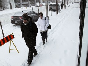 People make their way along snow-covered sidewalks on February 5, 2014. (TYLER BROWNBRIDGE/The Windsor Star)