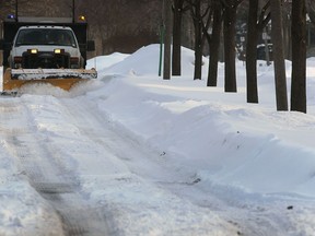 A snowplow makes its way down Askin Ave. Tues. Feb 18, 2014, in Windsor, Ont. Officials are concerned that the melting of the accumulated snow may cause flooding. (DAN JANISSE/The Windsor Star)