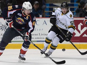 Windsor's Slater Koekkoek, left, and London's Tim Bender battle for the puck Tuesday, Feb. 18, 2014, at the WFCU Centre in Windsor. The Knights beat the Spitfires 6-5 in overtime. (DAN JANISSE/The Windsor Star)
