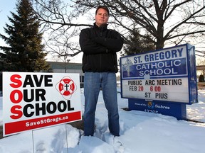 Mike Rohrer poses, Wednesday, Feb. 19, 2014, in front of the St. Gregory Catholic School in Tecumseh, Ont. Rohrer and other parents of students at the school are planning a rally Thursday to protest the possible closure of the school. (DAN JANISSE/The Windsor Star)