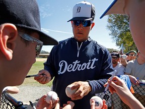 Detroit Tigers Miguel Cabrera signs autographs for fans after the team's first full squad workout of baseball spring training in Lakeland, Fla., Tuesday, Feb. 18, 2014. (Associated Press/Gene J. Puskar)