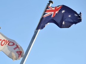 A damaged Australian flag, right, flies next to the Toyota flag at their Toyota Motor Corporation Altona manufacturing plant in Melbourne on Feb.10, 2014. Toyota said it will stop making cars in Australia in less than four years, banging the final nail in the coffin of country's auto industry, despite appeals to stay by Prime Minister Tony Abbott. (Paul CROCKPAUL CROCK/AFP/Getty Images)