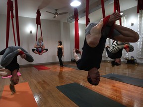 Son Nguyen teaches a class of aerial yoga recently at the Breathe Pilates and Fitness Studio in Windsor. (DAN JANISSE / The Windsor Star)
