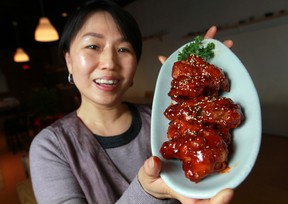Roci Chung, manager at Emo Ne Korean Restaurant, is pictured with a plate of Y Y chicken. (DAX MELMER / The Windsor Star)