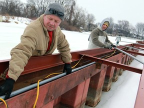Dave Robichaud, left, and Ernad Cerimagic work on the dock  at the South Port Sailing Club, Saturday, March 8, 2014.  Members of the club are reconfiguring the harbour due to ongoing low water levels.  (DAX MELMER/The Windsor Star)