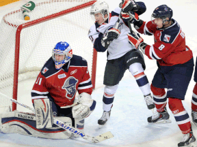 Windsor's Ryan Moore, centre, is checked by Kitchener's Dylan DiPerna in front of goalie Matthew Greenfield Friday in Kitchener. (DAVID BEBEE/Waterloo-Record)