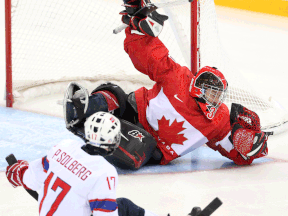 Kingsville's Corbin Watson, right, makes a save against Norway's Pallander Loyd-Remi Solberg during the bronze medal sledge hockey game at the 2014 Winter Paralympics in Sochi, Russia. (Leah Hennel/Calgary Herald)