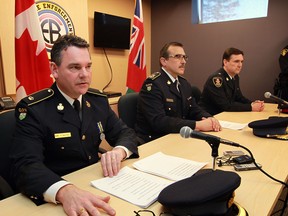 OPP Det. Insp. Greg Walton, left, reads from his prepared statement as OPP Deputy Commissioner Scott Tod and Windsor Police Superintendent John St. Louis, right, listen during an announcement from the Organized Crime Enforcement Bureau at the Essex OPP office on Manning Road Friday March 7, 2014. (NICK BRANCACCIO/The Windsor Star)