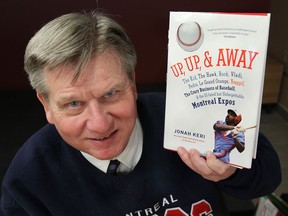 Photographer Russ Hansen poses Monday, March 24, 2014, with a book on the Montreal Expos called Up, Up & Away which features his work. (DAN JANISSE/The Windsor Star)