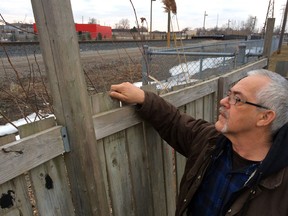 Joseph White, a resident in the 500 block of Memorial Drive, peers over his back fence at the CP Rail tracks, March 20, 2014.  (CRAIG PEARSON/The Windsor Star)