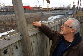 Joseph White, a resident in the 500 block of Memorial Drive, peers over his back fence at the CP Rail tracks, March 20, 2014.  (CRAIG PEARSON/The Windsor Star)