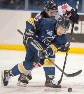 University of Windsor Lancers forward Mike Christou, front, and Acadia University Axemen forward Brett Thompson battle for the puck at the CIS University Cup in Saskatoon. (THE CANADIAN PRESS/Liam Richards)