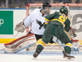 Carleton Ravens goaltender Francis Dupuis, left, makes a save on University of Alberta Golden Bear forward Johnny Lazo in third-period action at the CIS University Cup in Saskatoon. The Golden Bears defeat the Ravens 3-2. (THE CANADIAN PRESS/Liam Richards)