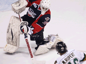 Windsor's Alex Fontinos, left, clears the puck in front of London's Matt Rupert at the WFCU Centre. (TYLER BROWNBRIDGE/The Windsor Star)