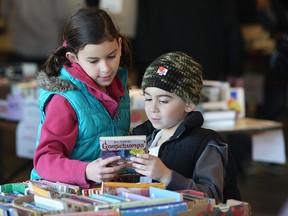 WINDSOR, ON., Alexandra Czudner, 8, and her brother Isaac Czudner, 6, check out books at the Windsor Star Raise a Reader annual book sale. (DAN JANISSE/The Windsor Star)