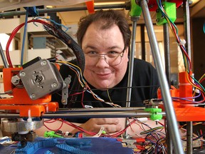 Paul Anderson, facility manager for Windsor Hackforge, looks through a 3D printer the group made. (DAN JANISSE/The Windsor Star)