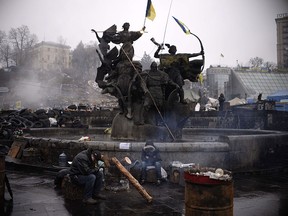 Men rest near a barricade on Independence square in central Kiev on March 3, 2014.  Russia has effectively "declared war" on Britain and the United States through its actions in Crimea, Ukraine's newly-freed opposition leader Yulia Tymoshenko warned on Monday.   AFP PHOTO / DIMITAR DILKOFF