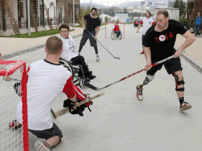 Kingsville's Corbin Watson, right, enjoys a friendly game of street hockey with his sledge hockey teammates in the athletes village in Sochi. (Leah Hennel/Calgary Herald)