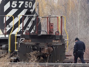 A Windsor Police officer searchs a rail yard near the 1400 block of Caron Ave. in Windsor, Ont. where a body part was found. (DAN JANISSE/The Windsor Star)