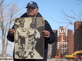 Colbert Prince, 63, a former resident of the Brewster-Douglass Projects, stands with picture of himself and his friend as children in front of a Brewster-Douglass high-rise, while at a press conference marking the final stage of demolition of the projects in downtown Detroit, Monday, March 10, 2014.  (DAX MELMER/The Windsor Star)