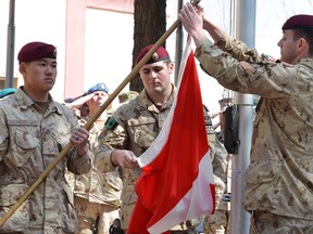 Master Cpl. Daniel Choong (left), Cpl. Harry Smiley (centre) and Cpl . Gavin Early (right) take down the Canadian flag for the last time in Afghanistan on  March 12, bringing an end to 12 years of military involvement in a campaign that cost the lives of 158 soldiers, including Windsor's Cpl. Andrew Grenon. THE CANADIAN PRESS/Murray Brewster