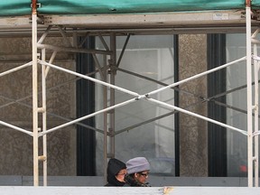 Pedestrians walk through scaffolding surrounding the Paul Martin Building in downtown Windsor, Ont. on Thursday, March 20, 2014. (DAN JANISSE/The Windsor Star)