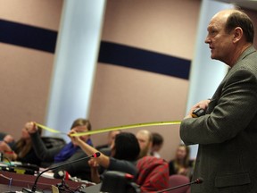 Peter Angerman makes a demonstration with a measuring tape at city council in Windsor on Monday, March 17, 2014.   (TYLER BROWNBRIDGE/The Windsor Star)