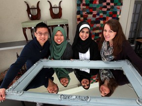 While visiting Cow Sang Row Studio, marketing students Josh Li, left, Amal Rahim, Malak Nigma and Larissa Pistan hold a mirror which once graced the wall of Mother's Pizza, a former Windsor landmark. (NICK BRANCACCIO/The Windsor Star)