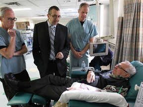 Doctors Carman Iannicello, left, Albert Kadri and Jack Speirs visit with dialysis patient Raymond Vaillancourt on Monday, March 24, 2014, at the Windsor Regional Hospital downtown campus. They will soon be able to reduce the number of amputations in patients undergoing dialysis thanks to a new piece of surgical equipment. (DAN JANISSE/The Windsor Star)
