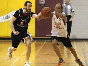 The Dunks for Dialysis fundraising event was held Sunday, March, 30, 2014, at the Catholic Central High School in Windsor, Ont. The game between local doctors and medical students raises money for the Care for Kidneys Foundation. Medical student Steve Malone (L) and Lawrence Aoun battle for the ball during the game.   (DAN JANISSE/The Windsor Star)