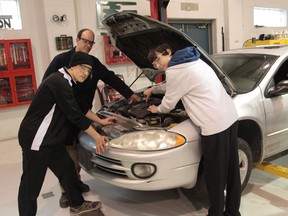 Ecole Lajeunesse auto shop teacher, Antoine Labbe, left,  and students Austin Comtois and Nicholas Marchand, work on a vehicle donated by the Rafih Automotive Group on March 19, 2014.   The vehicle will be repaired by the students and dontated to a family in the city.  Other partners in the project are  Lowe's, Rafih Automotive, Beverly Tire, Benson Automotive, Family Services Windsor-Essex, and the United Way. Jason Kryk/The Windsor Star)