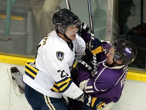 Windsor's Drew Palmer, left, checks Western's Steve Reese at Windsor Arena. (TYLER BROWNBRIDGE/The Windsor Star)