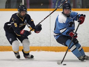 St. Joseph's Mason Ouellette, left, and Massey's Logan Young battle for the puck during their game Monday, March 3, 2014, at South Windsor Arena. (DAN JANISSE/The Windsor Star)