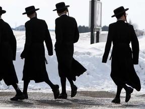 Members of the Lev Tahor ultra-orthodox Jewish sect walk down a street while an emergency motion in the child custody case is held at the courthouse in Chatham, Ont., Wednesday, March 5, 2014. (THE CANADIAN PRESS/Dave Chidley)