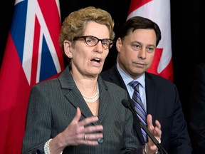 Ontario Premier Kathleen Wynne (left) speaks and Minister of Training, Colleges and Universities Brad Duguid listens after meeting with education representatives at Queen's Park in Toronto Thursday, March 27, 2014. THE CANADIAN PRESS/Frank Gunn