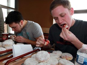 Paczki eating contestants Jacob Ritchie, left, and Andrew Murray do their best to keep up with some big appetites at Tim Hortons Tuesday March 4, 2014. (NICK BRANCACCIO/The Windsor Star)