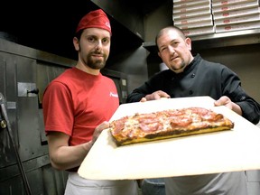Corporate pizza chef Dean Litster, left, and executive chef Marco Malizia from Armando’s Pizza hold up a deep-dish pizza made at the Cabana Road location Saturday, March 29, 2014. Armando’s Pizza entered four competitions at the 30th annual International Pizza Expo in Las Vegas and came home finishing in the top-five in every category. (JOEL BOYCE/The Windsor Star)