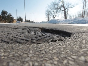 A sunken manhole cover on Banwell Road  in Windsor is one of a multitude of bumpy driving conditions in the Windsor area. (JASON KRYK/The Windsor Star)
