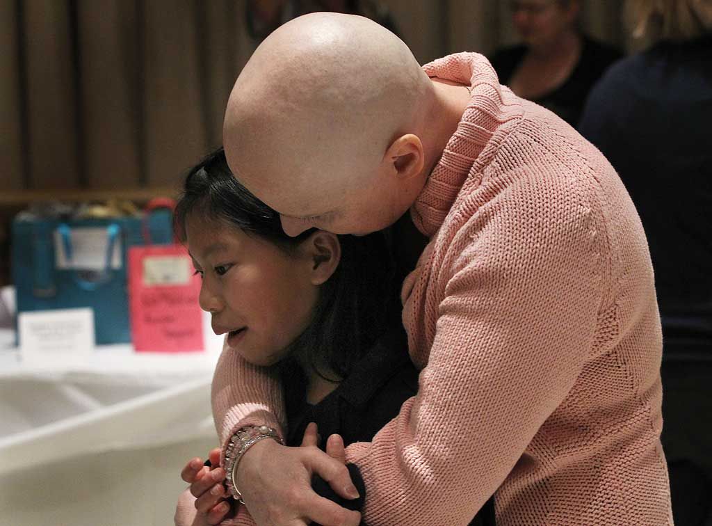 Amanda Ryall gives her daughter Molly, 9, a hug during a pasta luncheon fundraiser, Sunday, March 28, 2014, at the Ciociaro Club in Windsor, Ont. She and her husband Francis are fighting cancer. (DAN JANISSE/The Windsor Star)
