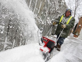 Bruce Fenn clears his driveway with a snow blower on Roseland Drive West in the midst of a snow storm Wednesday, March 12, 2014.  (DAX MELMER/The Windsor Star)