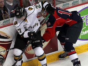 The Windsor Spitfires Ryan Foss battles along the boards with the London Knights Brett Welychka at the WFCU Centre in Windsor on Thursday, March 27, 2014.                        (TYLER BROWNBRIDGE/The Windsor Star)