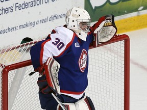 The Windsor Spitfires Dalen Kuchmey fishes the puck out of the net after giving up a short handed goal to the London Knights at the WFCU Centre in Windsor on Tuesday, March 25, 2014.                       (TYLER BROWNBRIDGE/The Windsor Star)