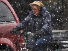 A cyclist is rides in downtown Windsor on March 25, 2014, during a springtime snow fall . (DAN JANISSE/The Windsor Star)