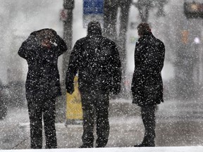 Pedestrians are shown in downtown Windsor, Ont. on Tuesday, March 25, 2014, during springtime snow flurries. (DAN JANISSE/The Windsor Star)