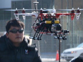 The University of Windsor took a high-tech approach to recording a ground breaking ceremony on Wednesday, March 26, 2014, for the new Welcome Centre project. Professor Min Bae operated a drone camera above the group assembled and recorded video of the event. Bae is shown controlling the drone during the event.  (DAN JANISSE/The Windsor Star)