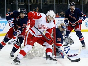 Brian Lashoff of the Detroit Red Wings wraps around the net as Derick Brassard and Henrik Lundqvist of the New York Rangers defend at Madison Square Garden on March 9, 2014 in New York City.The New York Rangers defeated the Detroit Red Wings 3-0.  (Elsa/Getty Images)