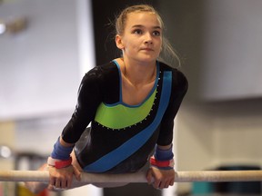 Holly Lavigne works on the bars during a training session. (DAN JANISSE / The Windsor Star)