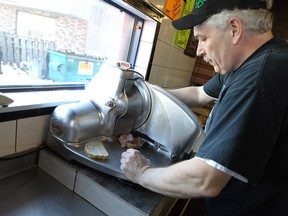 Terry Crozier creates a corned beef sandwich at Malic's in Windsor. (TYLER BROWNBRIDGE / The Windsor Star)