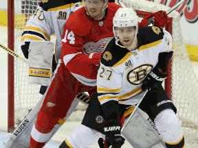 Boston goalie Tuukka Rask, left, and teammate Dougie Hamilton, right,  battle with Gustav Nyquist of the Red Wings at Joe Louis Arena. (Photo by Leon Halip/Getty Images)